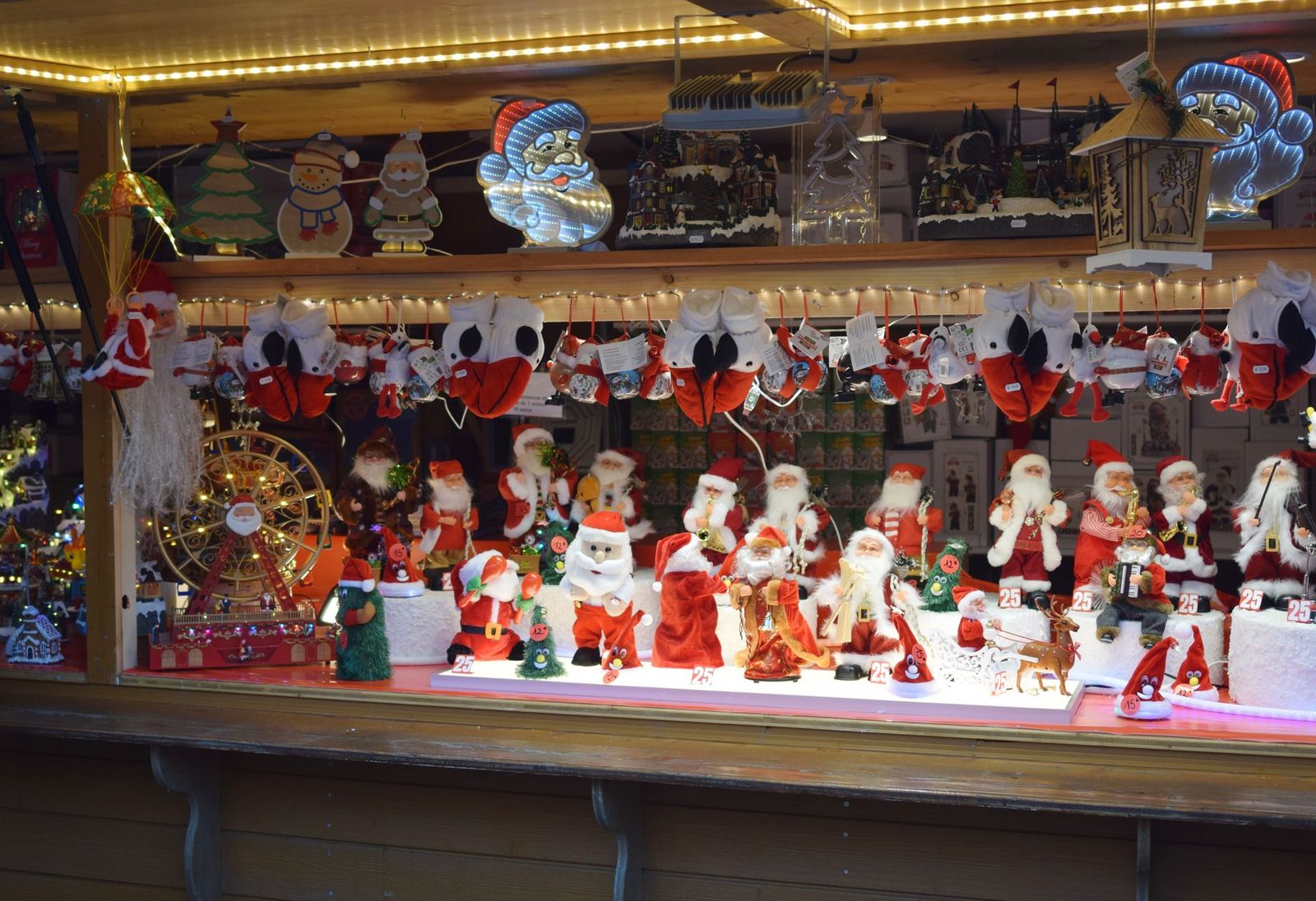Festive Christmas market stall displaying various holiday decorations and Santa Claus figures in Strasbourg, France.