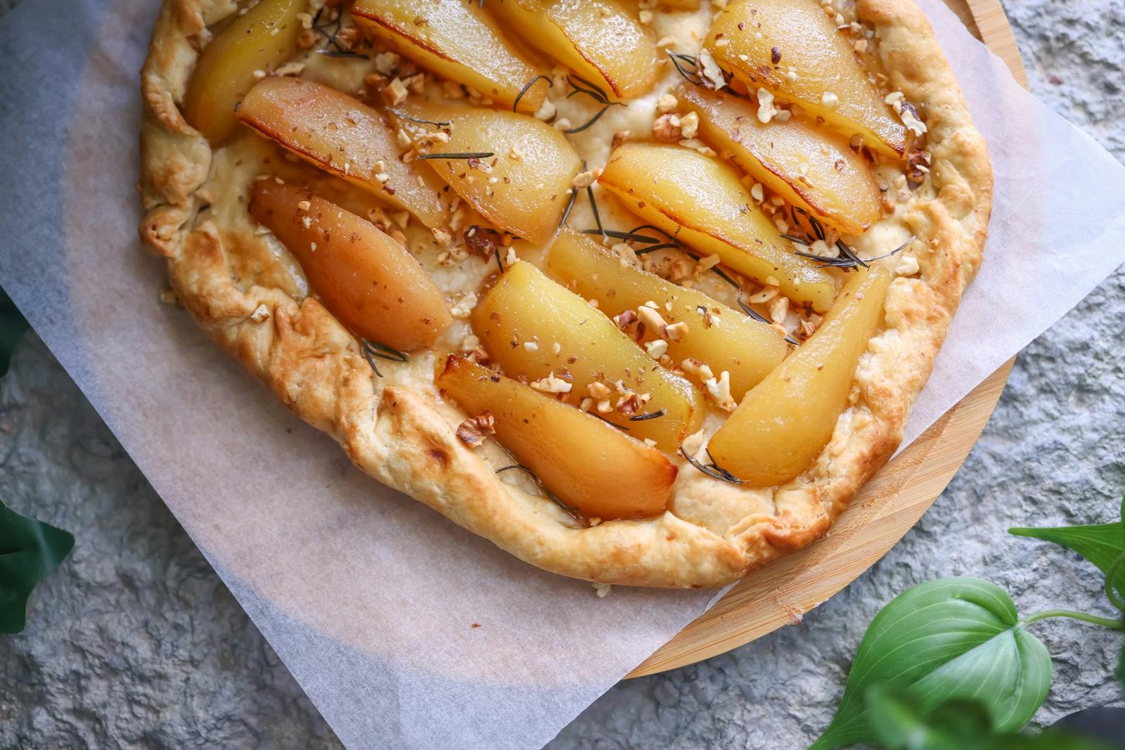 Delicious homemade pear tart with fresh ingredients on a rustic table.