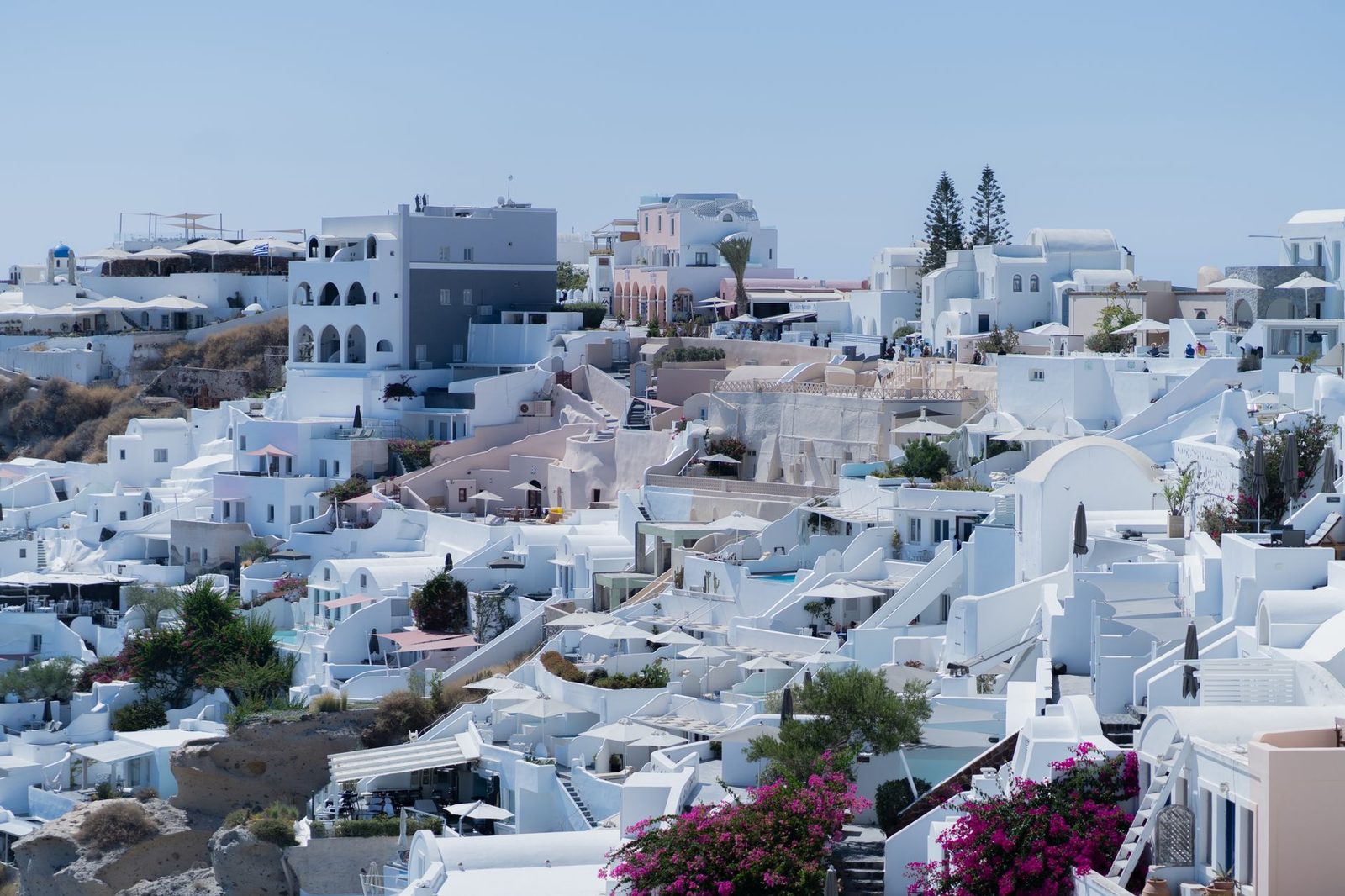 Beautiful view of iconic white buildings in a Santorini village overlooking the sea.