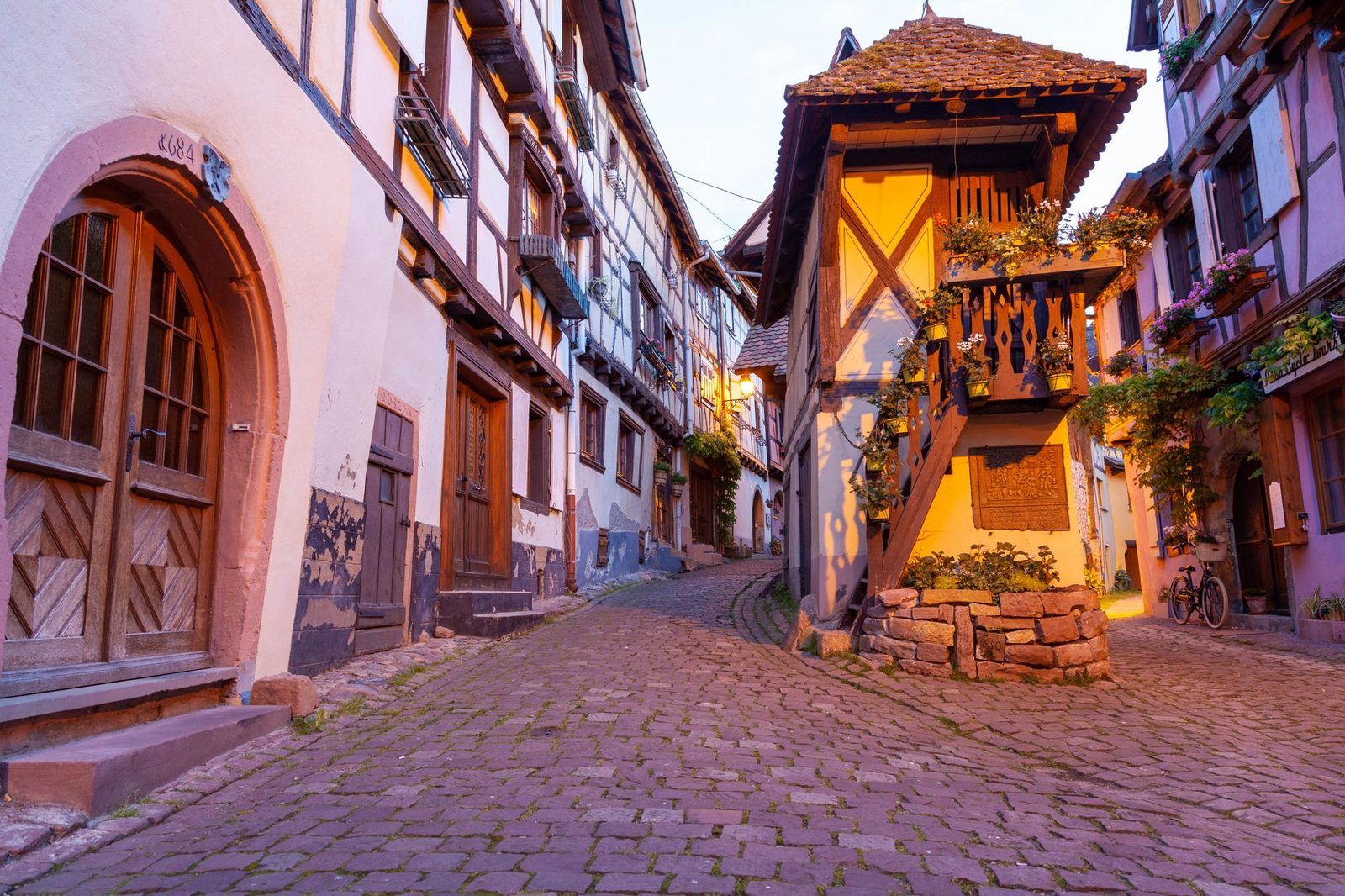 Picturesque cobblestone street in Eguisheim, showcasing traditional Alsatian architecture.