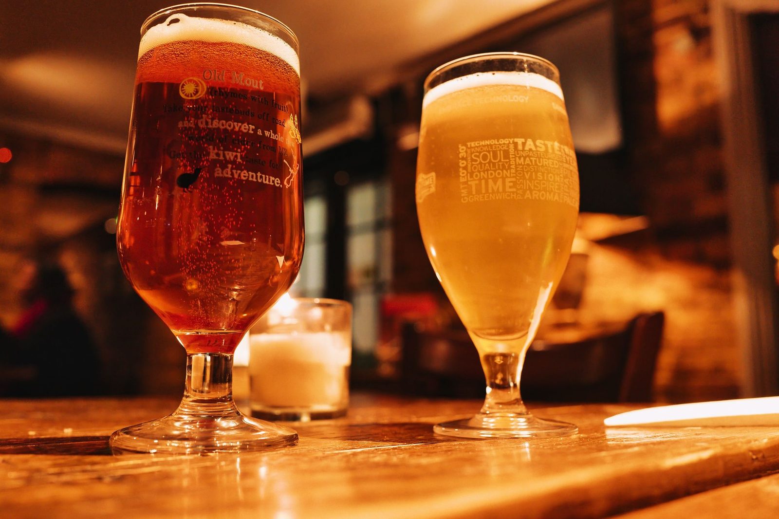 Warm and inviting pub setting with two beers on a wooden table.