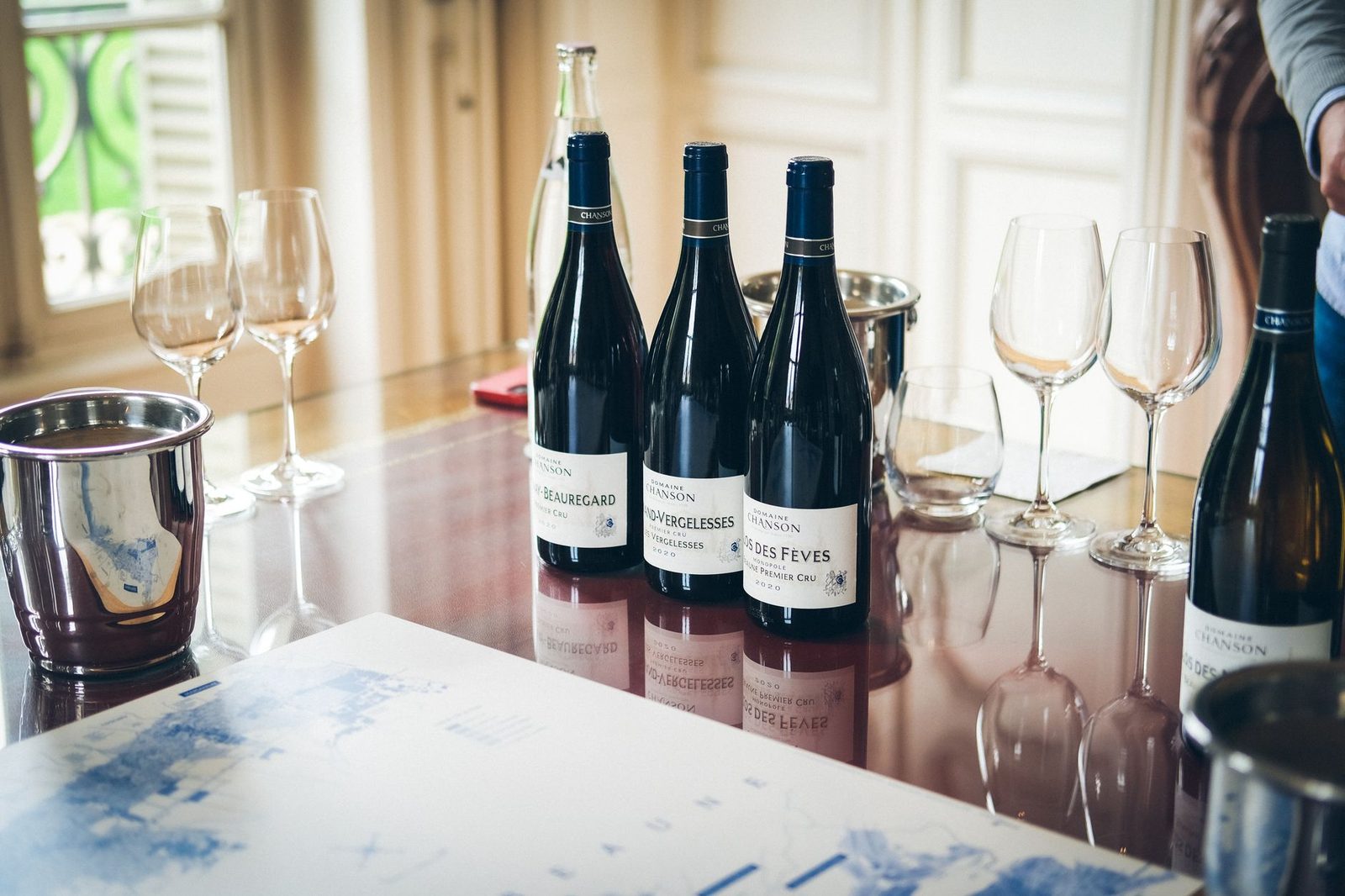 Elegant wine tasting setup with bottles and glasses in Beaune, France.