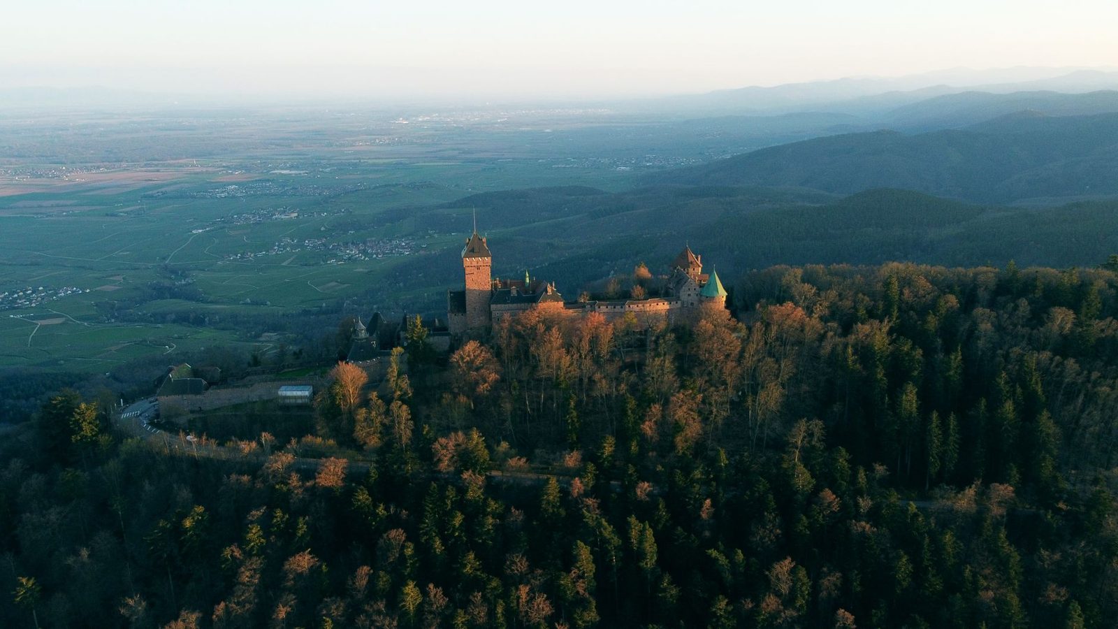 Stunning aerial shot of Haut-Kœnigsbourg Castle amidst the forested landscape of Kintzheim, France.