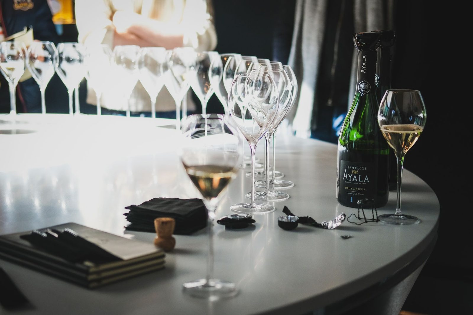 A close-up of champagne glasses and bottle on a table in Aÿ-Champagne, France.