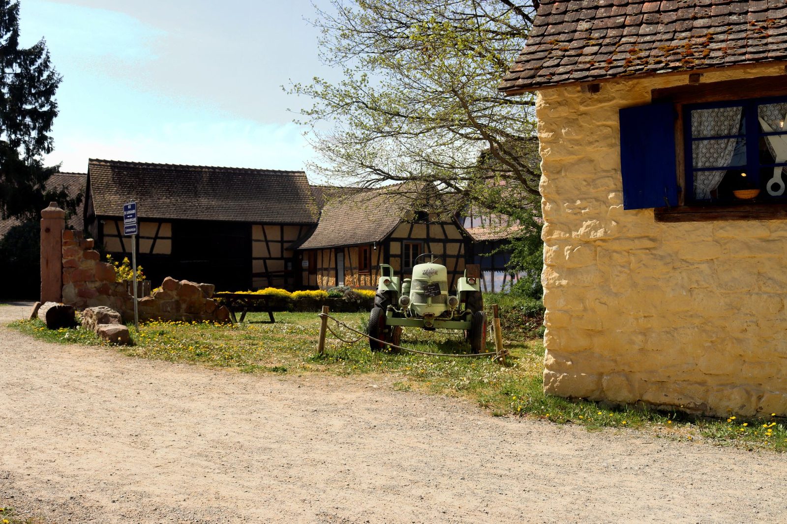 Charming rural scene in Ungersheim, France with vintage tractor and half-timbered houses.