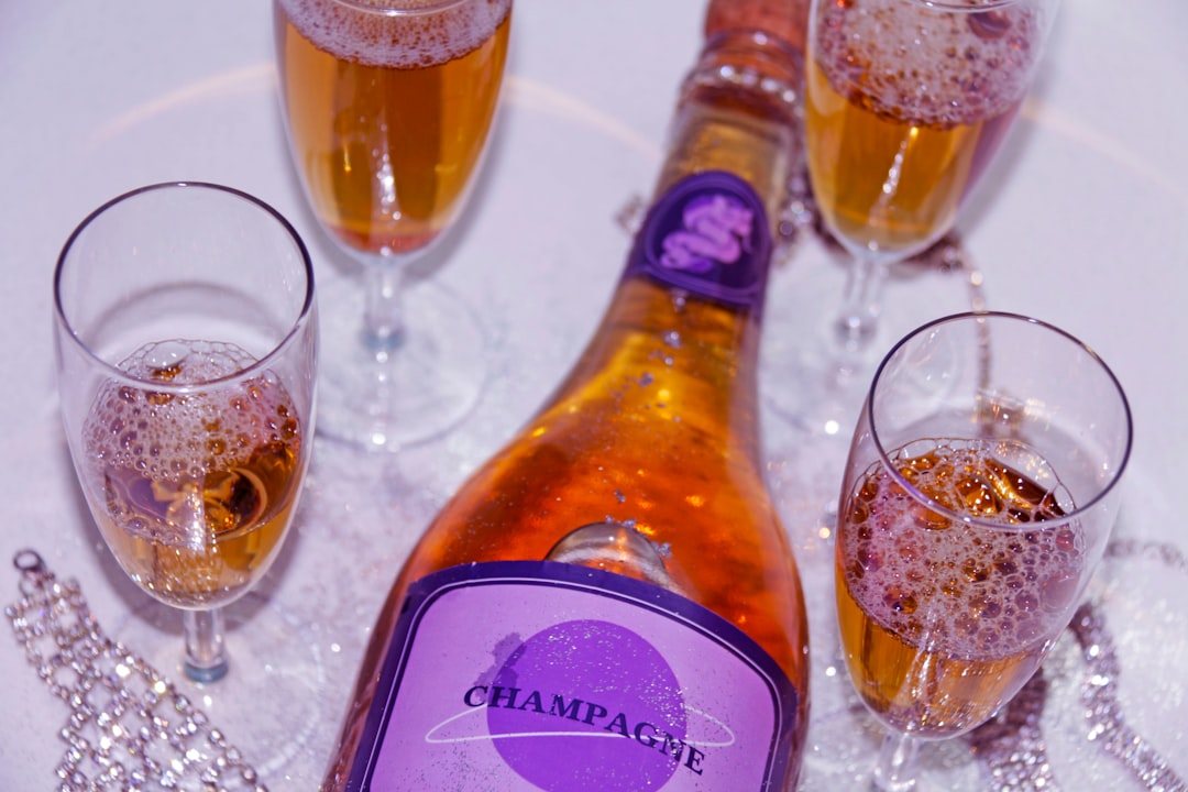 a bottle of champagne next to three glasses of champagne
