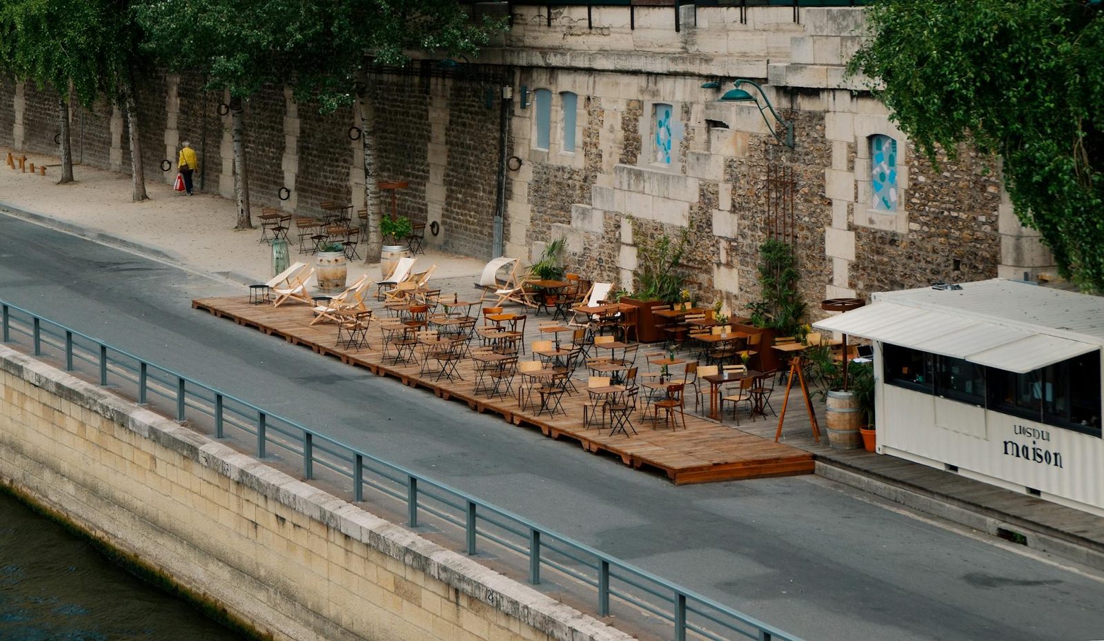 A charming outdoor café terrace along the Seine River in Paris.