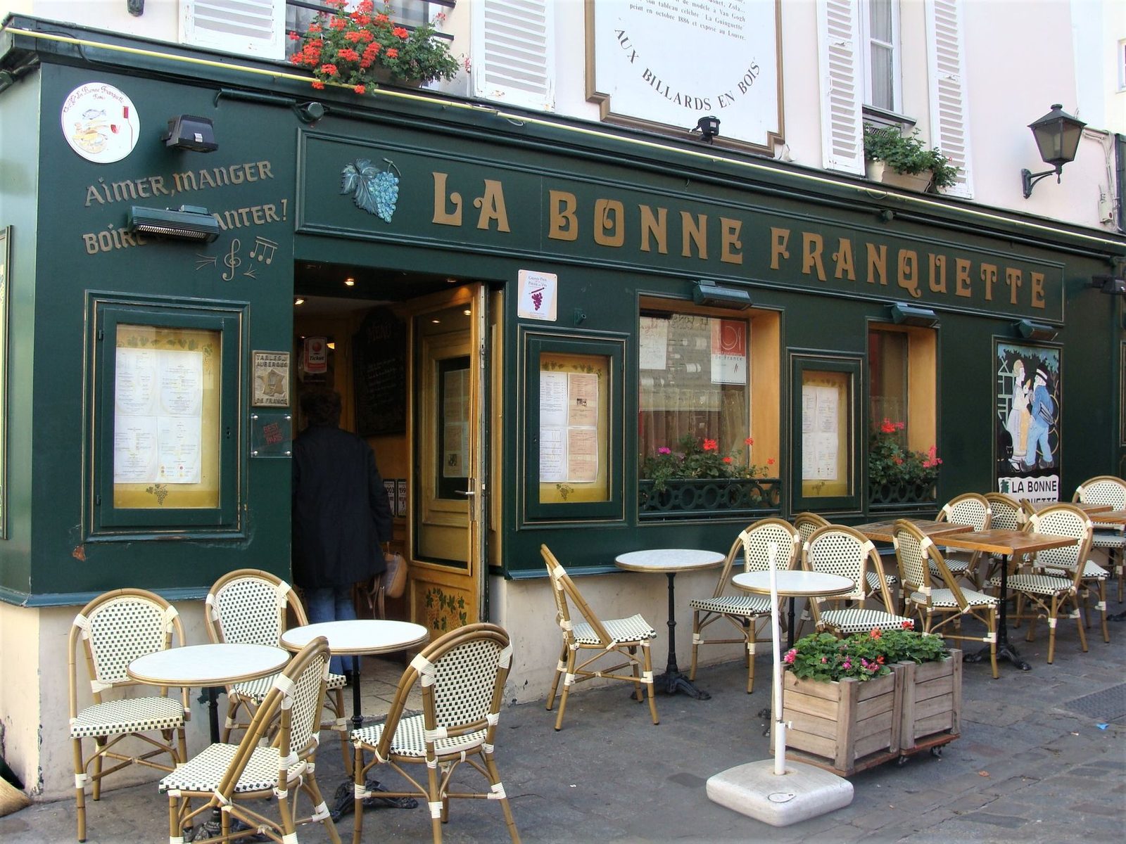 Charming Parisian café La Bonne Franquette with outdoor seating on a sunny day in Montmartre, Paris.