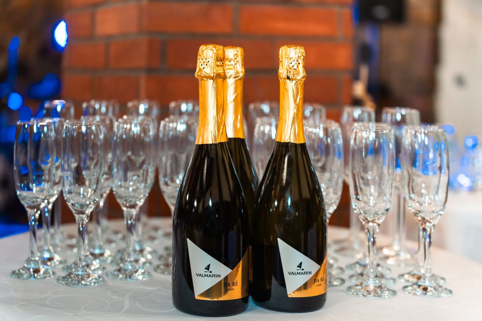 Champagne bottles with empty flutes on a table, set for a celebration or event.