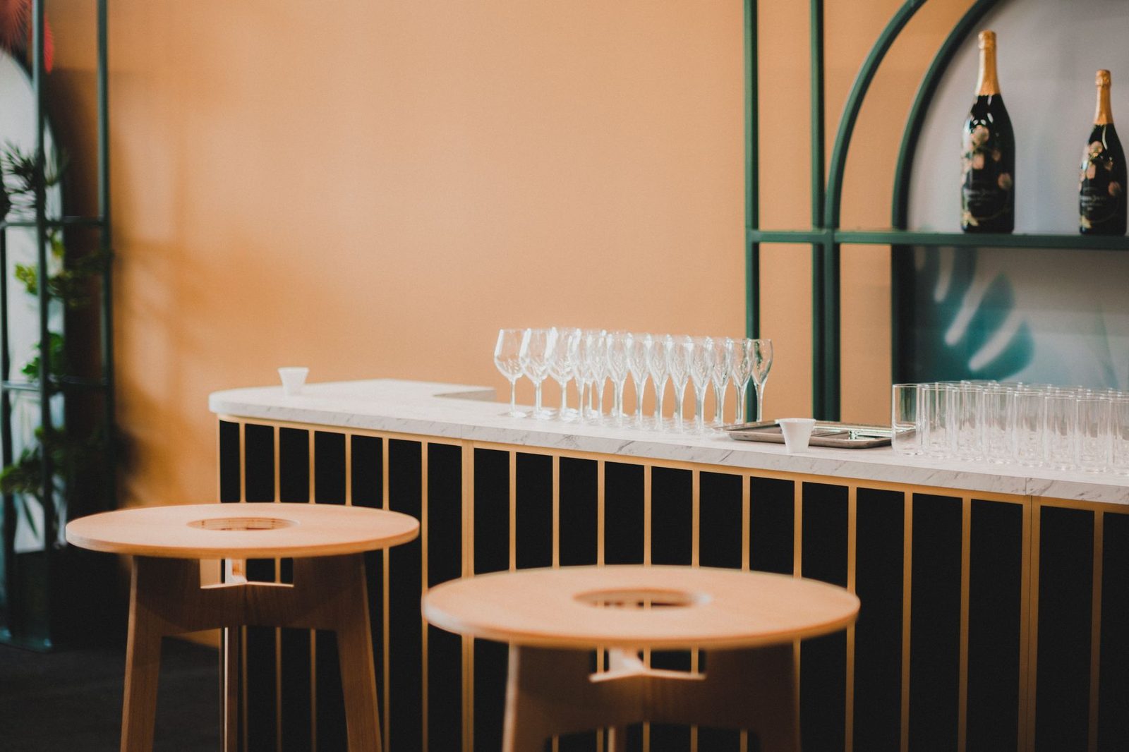 Elegantly styled modern bar counter featuring glasses and bottles, perfect for luxurious interiors.
