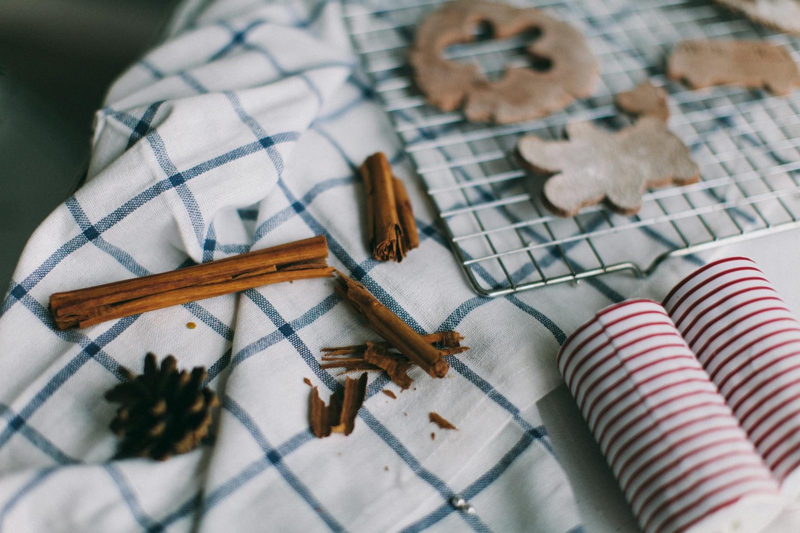 Warm home baking scene with cinnamon, cookie cutouts, and festive decor, perfect for holiday themes.