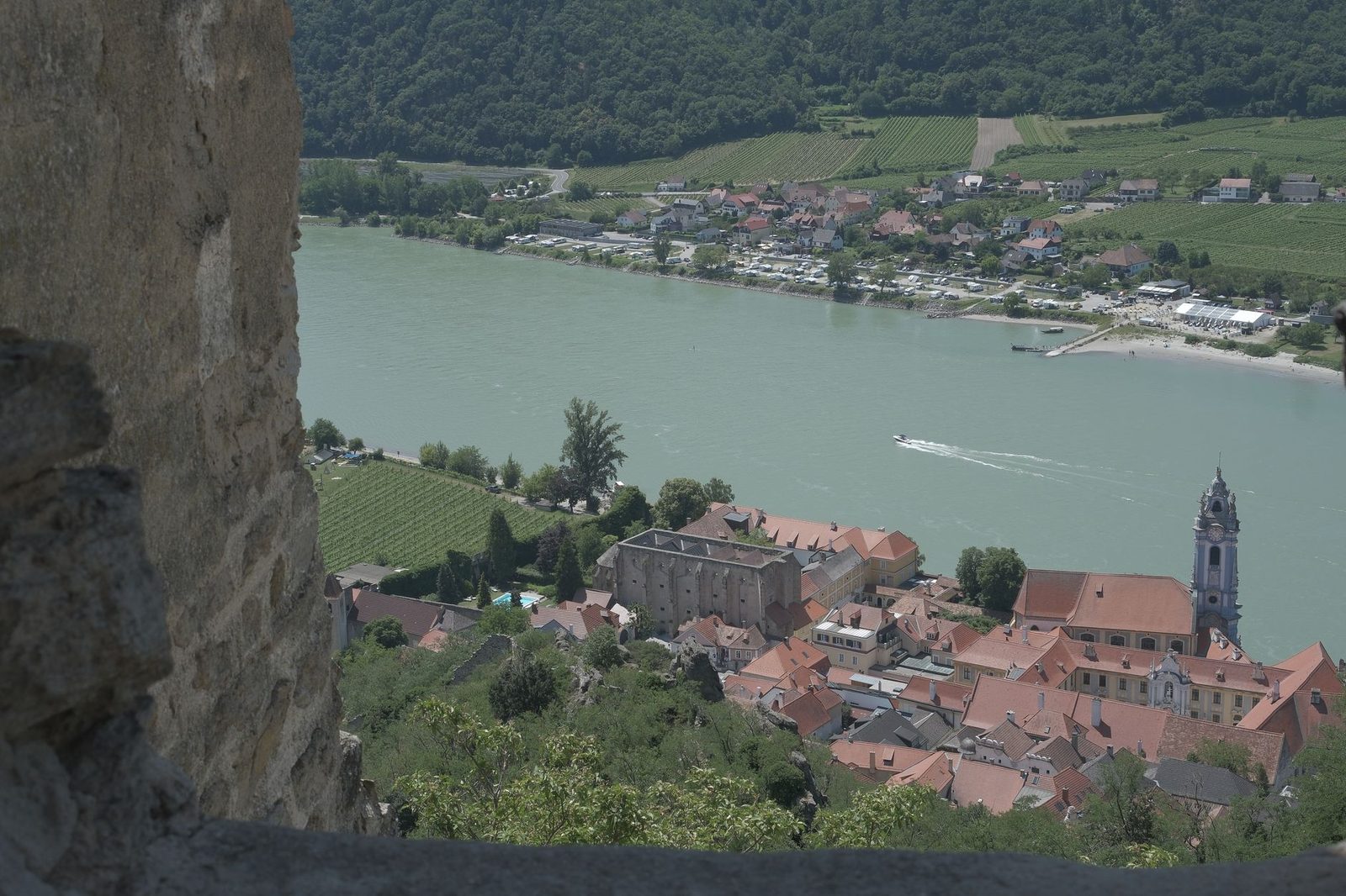 Explore the scenic view of Dürnstein and the Danube River framed by an ancient fortress wall.