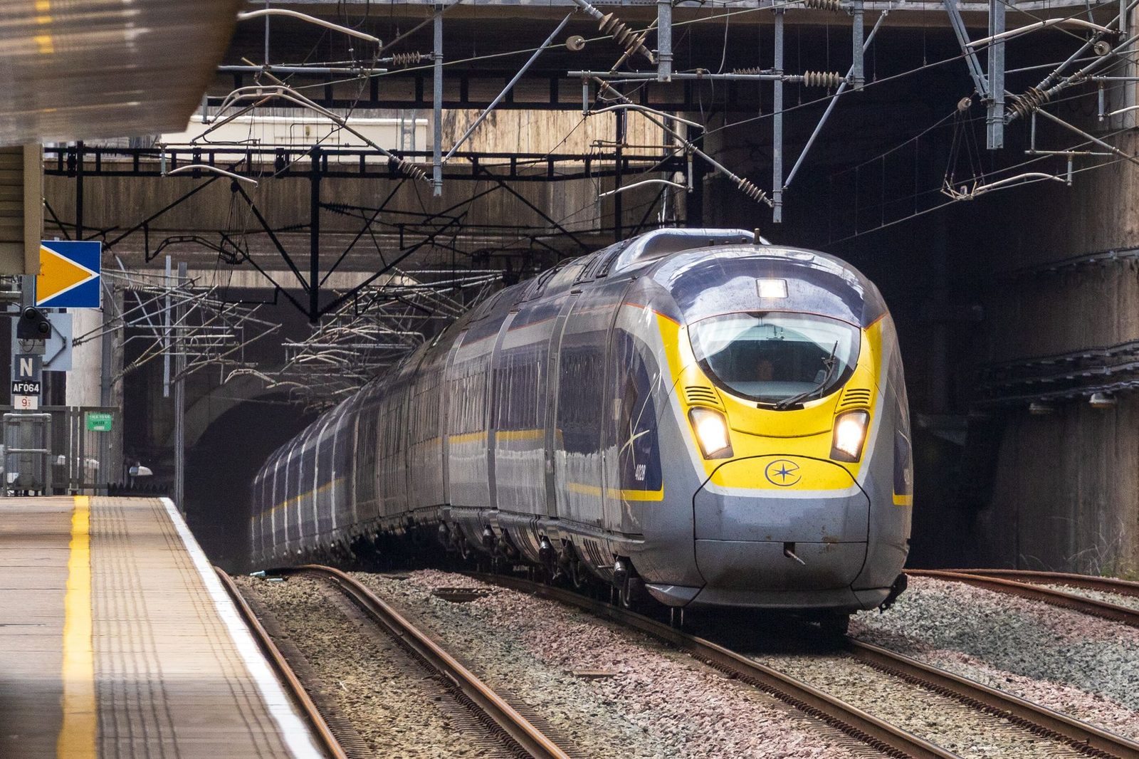 Eurostar high-speed train approaches platform exit from a tunnel, showcasing modern rail travel.