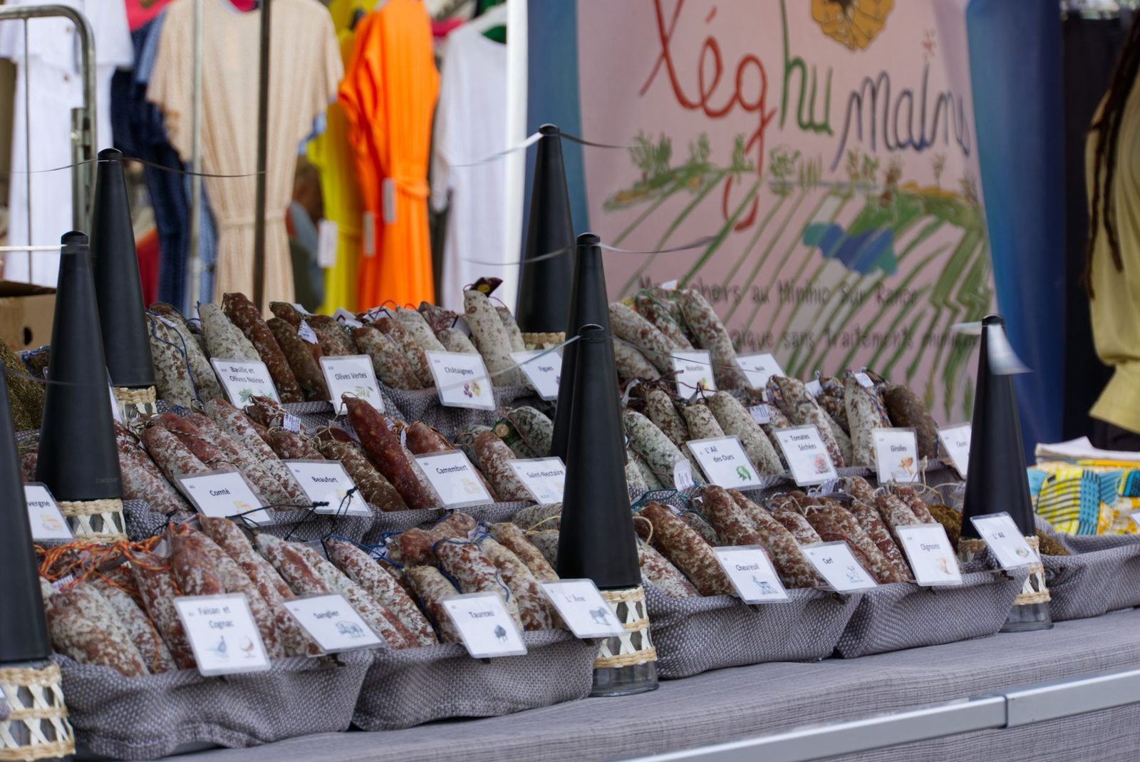 Colorful market stall in Dinard, France showcasing a variety of artisan sausages.