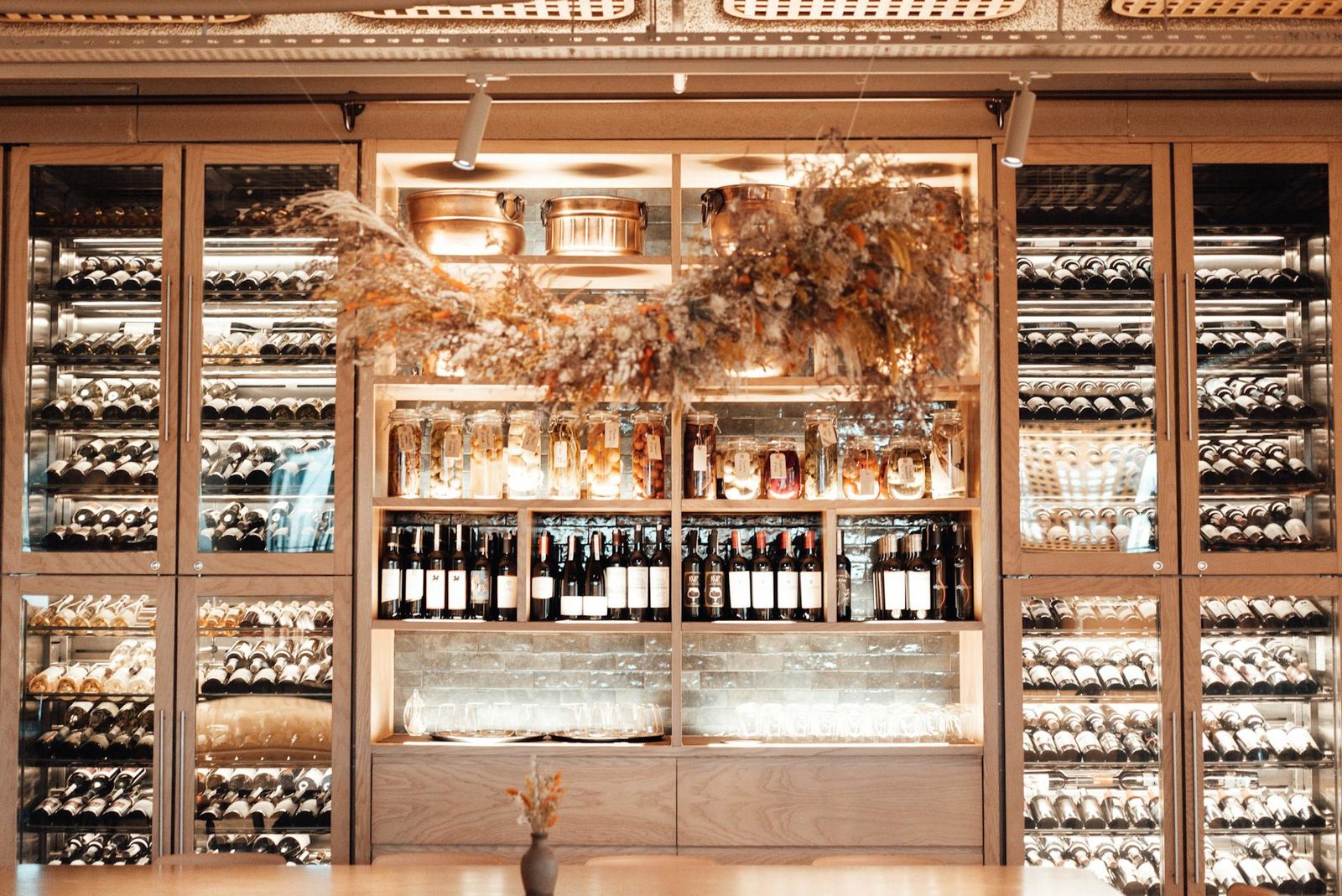 Collection of various wines placed in showcase of modern enoteca with stylish furniture and creative decoration
