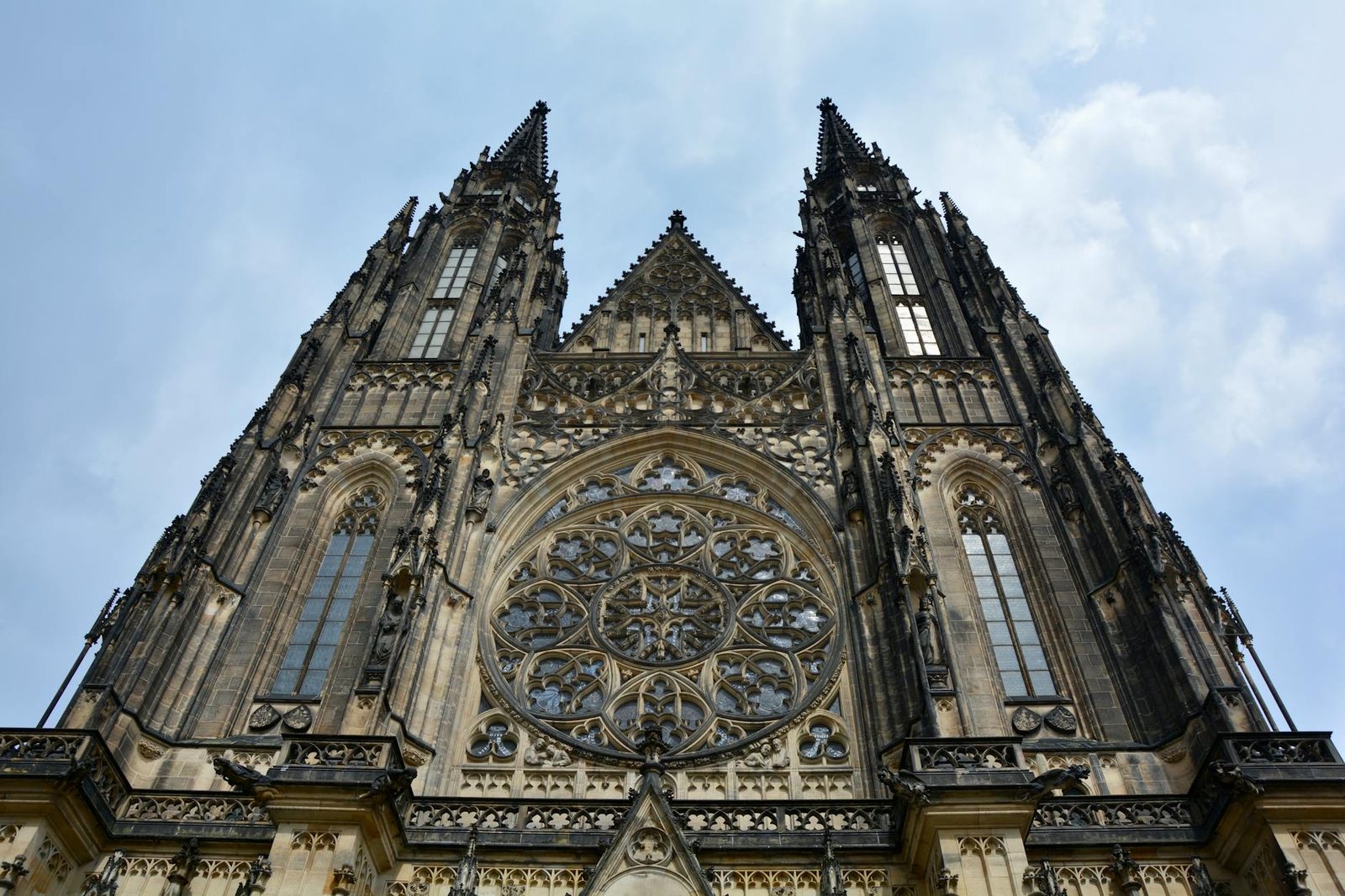 Low angle view of St. Vitus Cathedral's intricate Gothic facade in Prague.