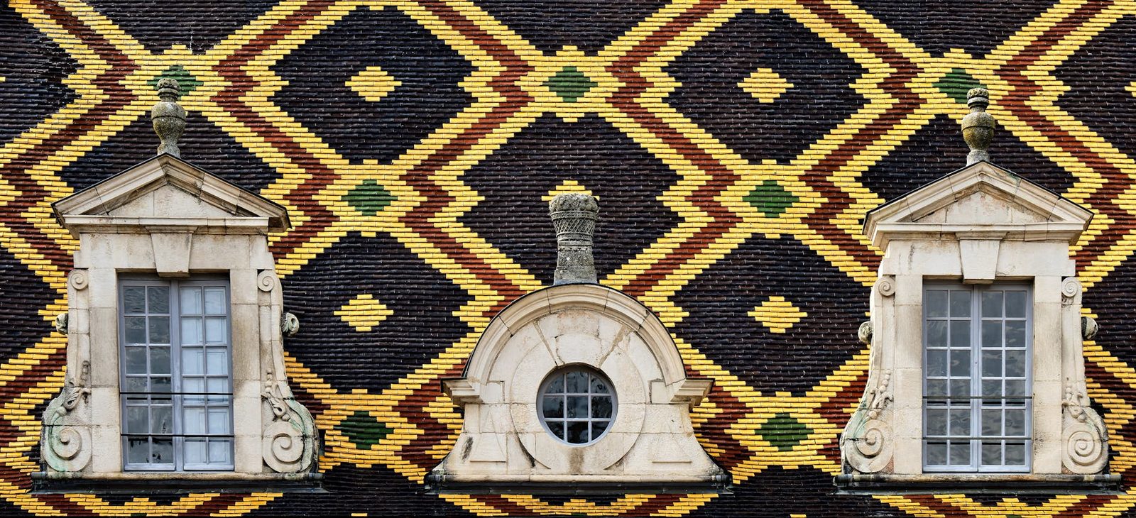 Traditional Bourgogne roof with colorful geometric patterns and classic French windows.