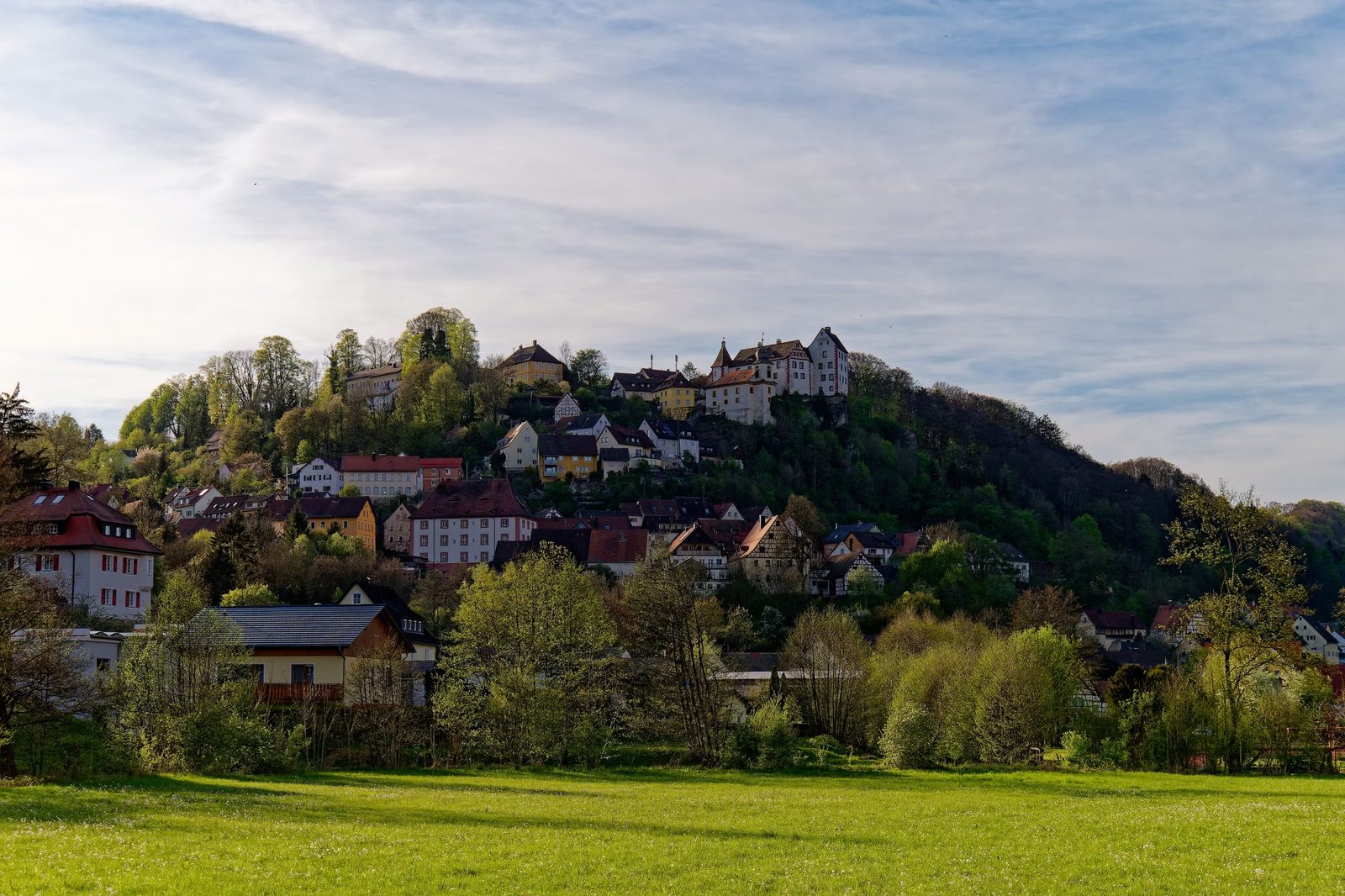 Picturesque hillside village of Egloffstein in Bavaria, Germany, surrounded by lush greenery.