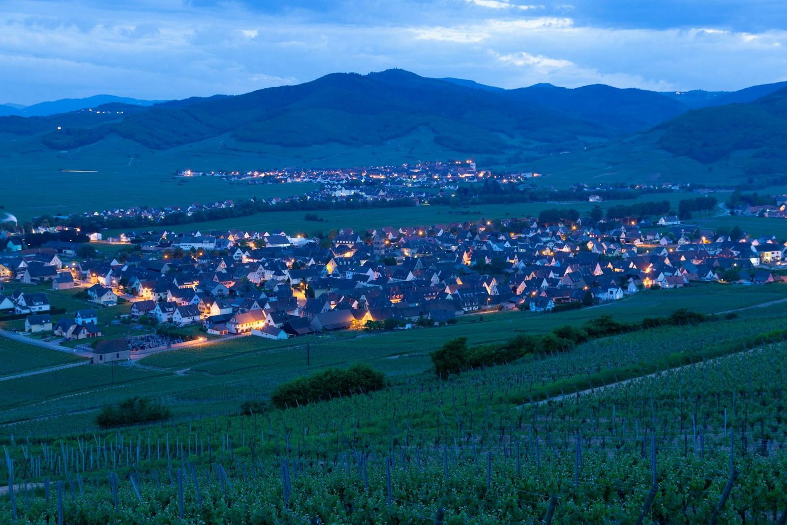 Explore the picturesque vineyard region and evening lights of Mittelwihr village, Grand Est, France.