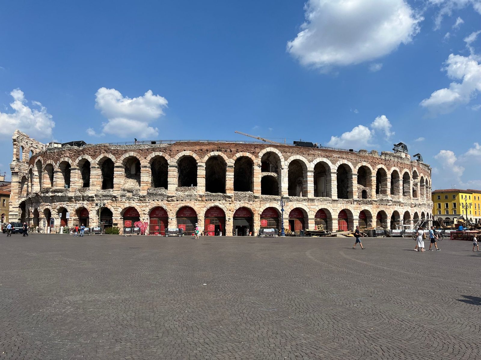The ancient Verona Arena stands majestic under clear blue skies, a symbol of Italian history and architecture.