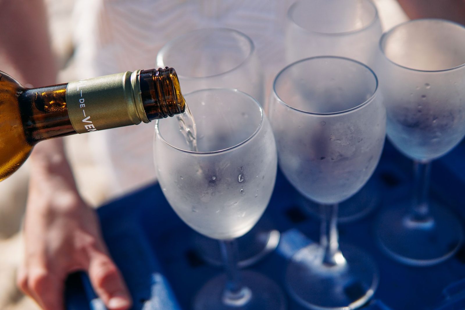 Chilled white wine being poured into frosted glasses, perfect for a summer gathering.