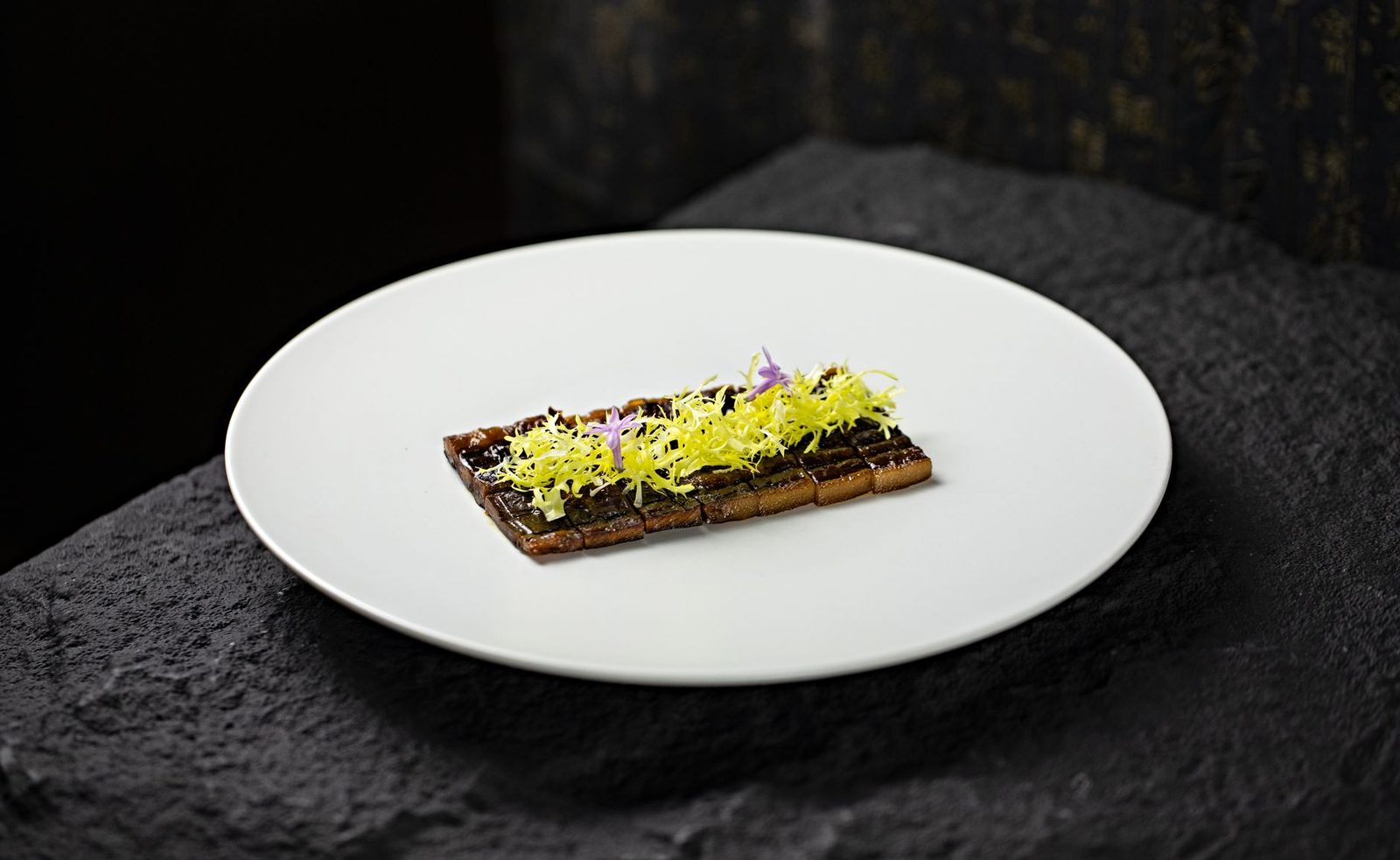 Elegant gourmet dish garnished with edible flowers on a white plate. Perfect for fine dining concepts.