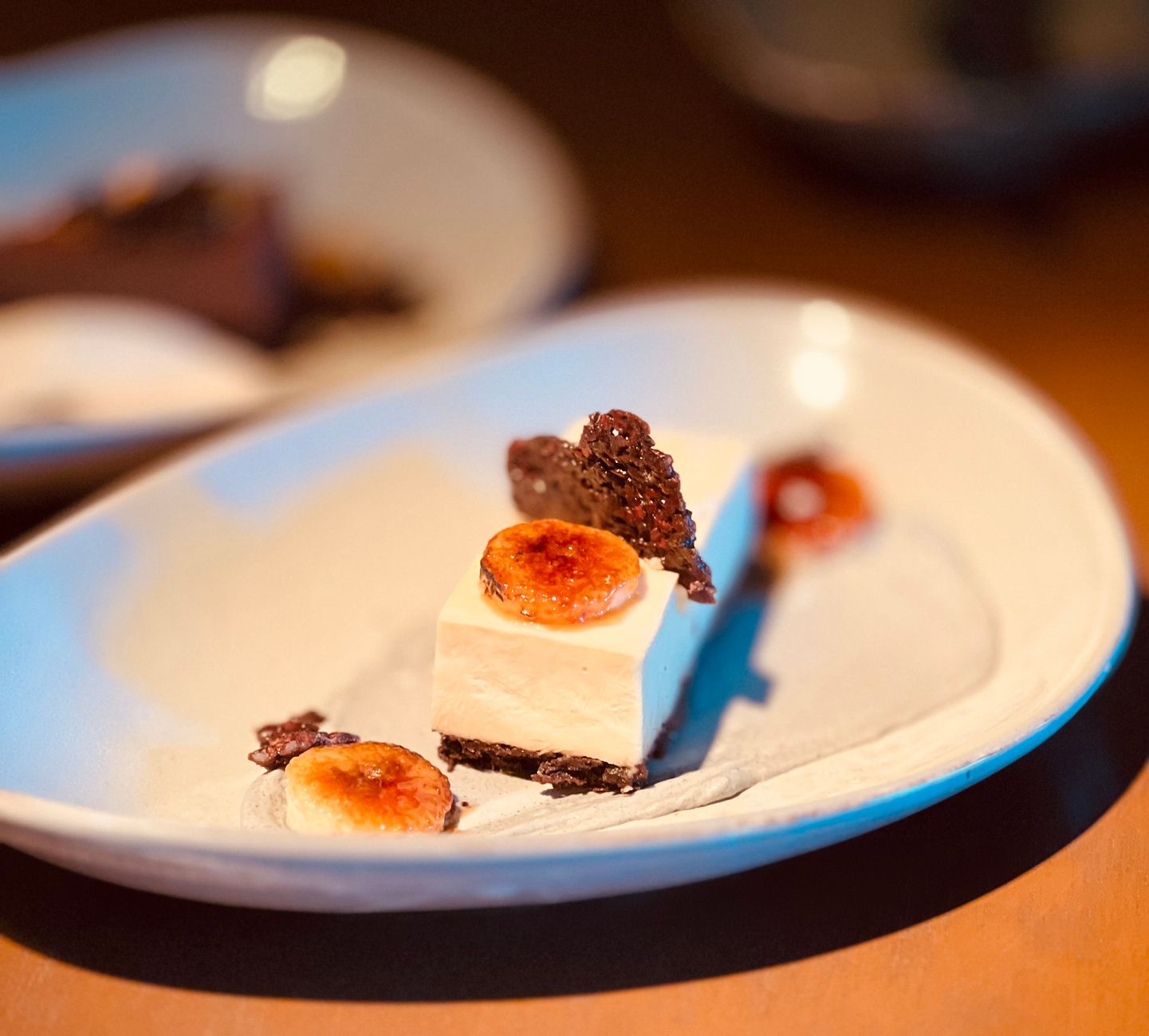 Elegant plated dessert featuring caramelized banana and chocolate crisps for a gourmet dining experience.