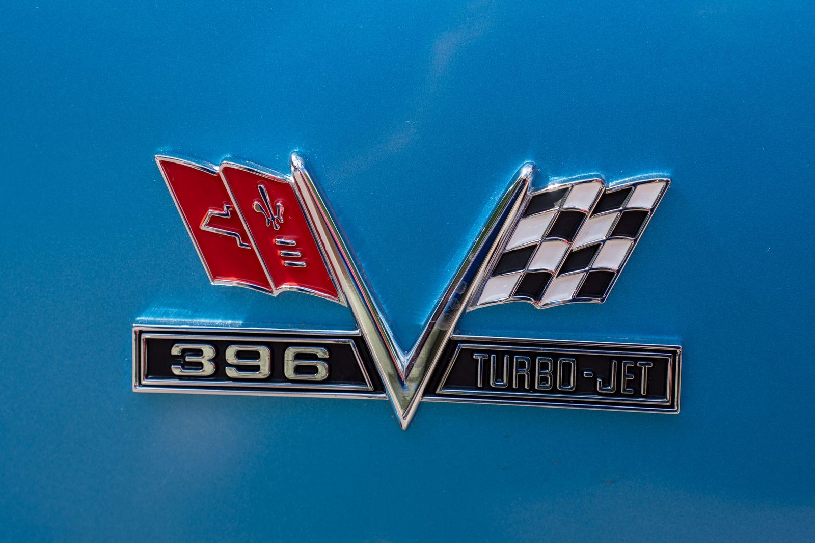 Close-up of a classic car emblem featuring a 396 Turbo-Jet badge on a blue background.